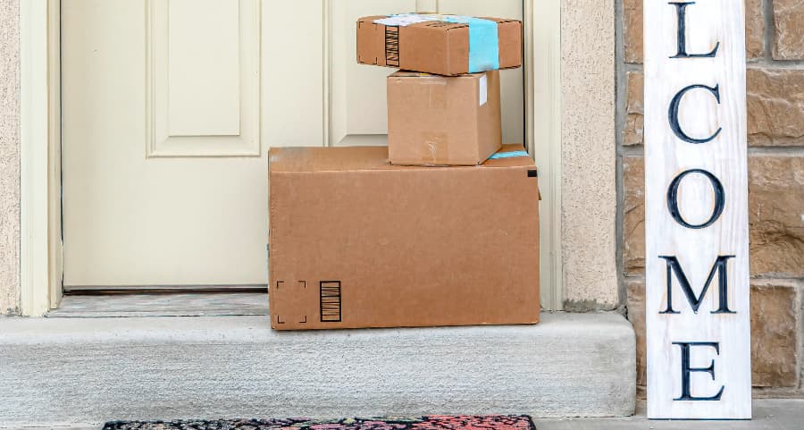 Packages on the doorstep of a home with a welcome sign in Albuquerque